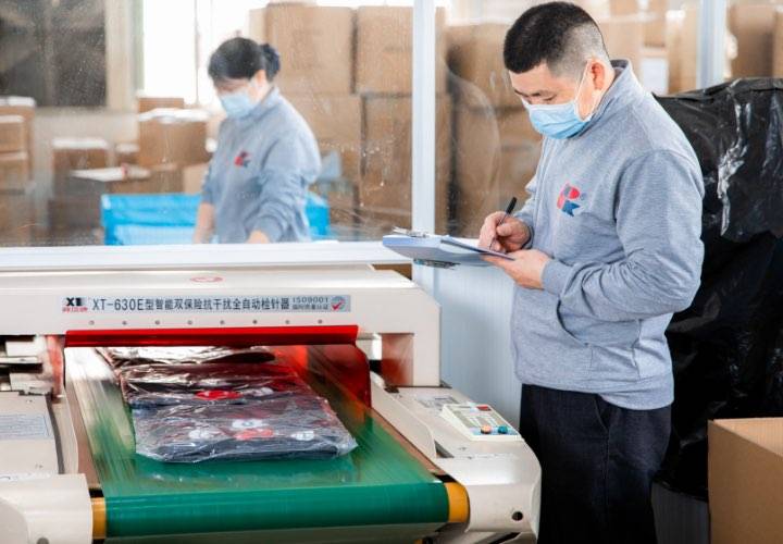 A staff member checks and records the product on the production line.