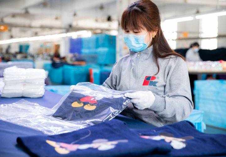A worker in work clothes is packing the custom bag product.